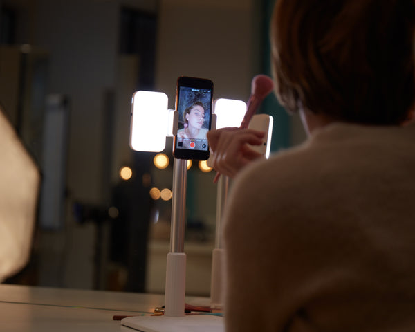 Utilisation du support TechRevolve Pro Pliaxi par une influenceuse make-up : éclairage professionnel et angle ajustable.